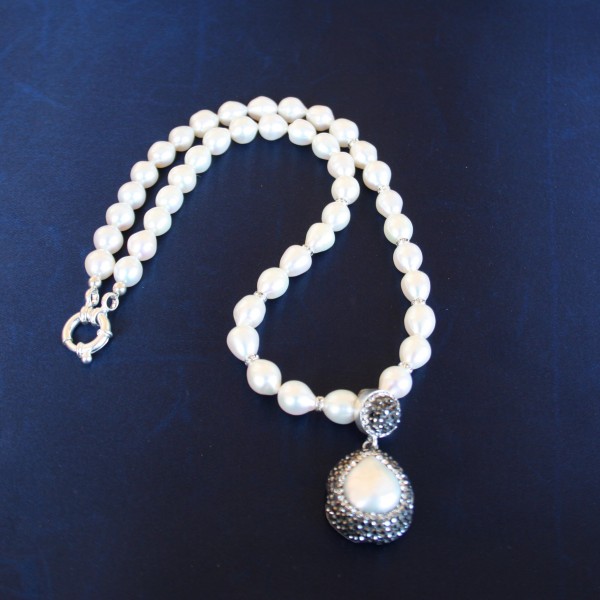 Collana di perle di acqua dolce con intermezzi di cristalli swarovski e pendente di  argento 925 con perla barocca e cristalli swarovski di alta qualità. Chiusura in argento 925.